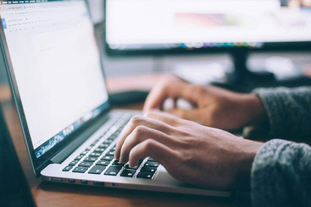Person schreibt am Laptop einen Fachartikel als Ausgangspunkt für Content Recycling