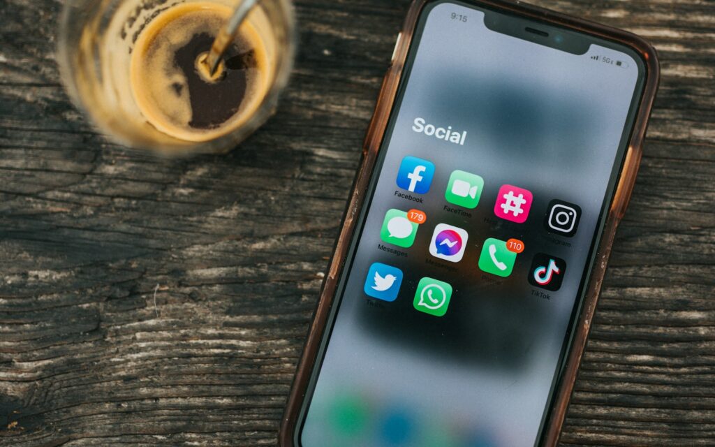 Smartphone mit Social-Media-Apps neben einer Tasse Kaffee