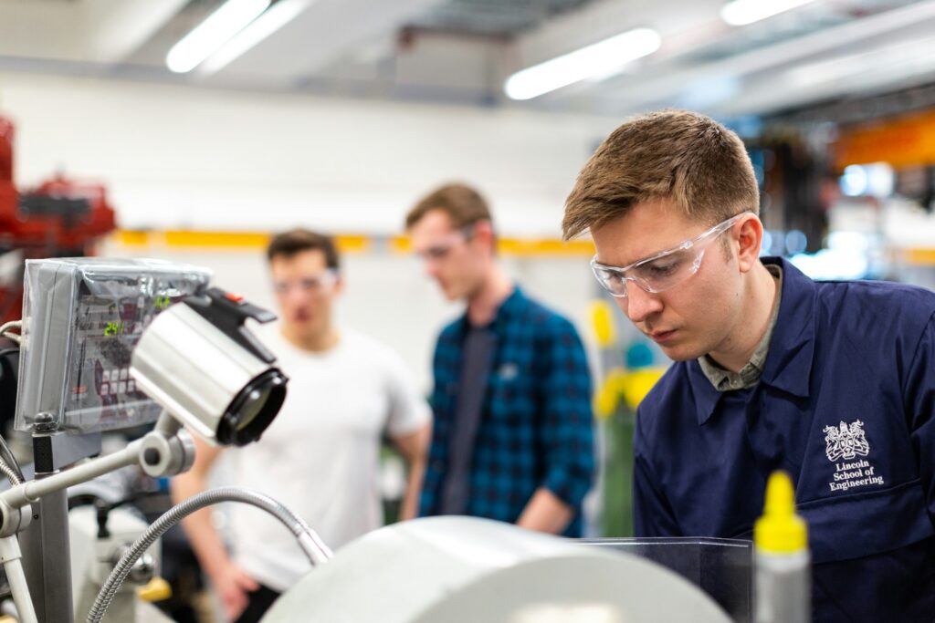 Auszubildender mit Schutzbrille bedient eine Maschine in der Lehrwerkstatt, gefilmt für Employer Branding TikTok