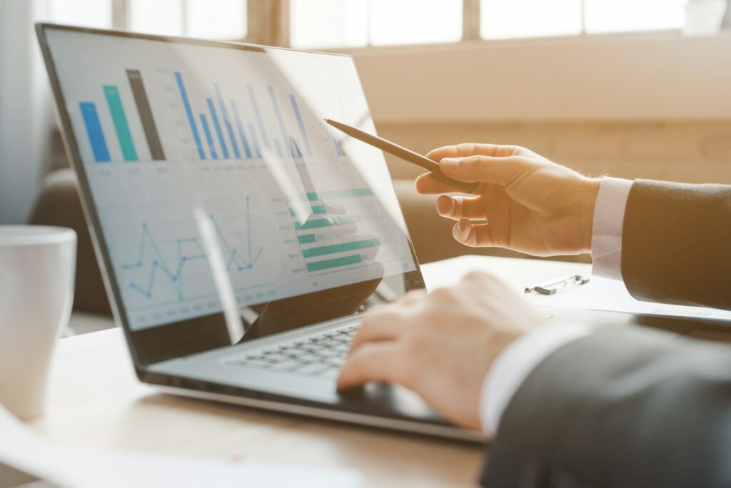 Person analysiert Diagramme am Laptop zur Vorbereitung der Gehaltsverhandlung im Marketing