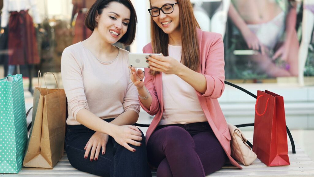 Zwei junge Frauen schauen lachend gemeinsam auf ein Smartphone – typische Situation für Gen Z Marketing