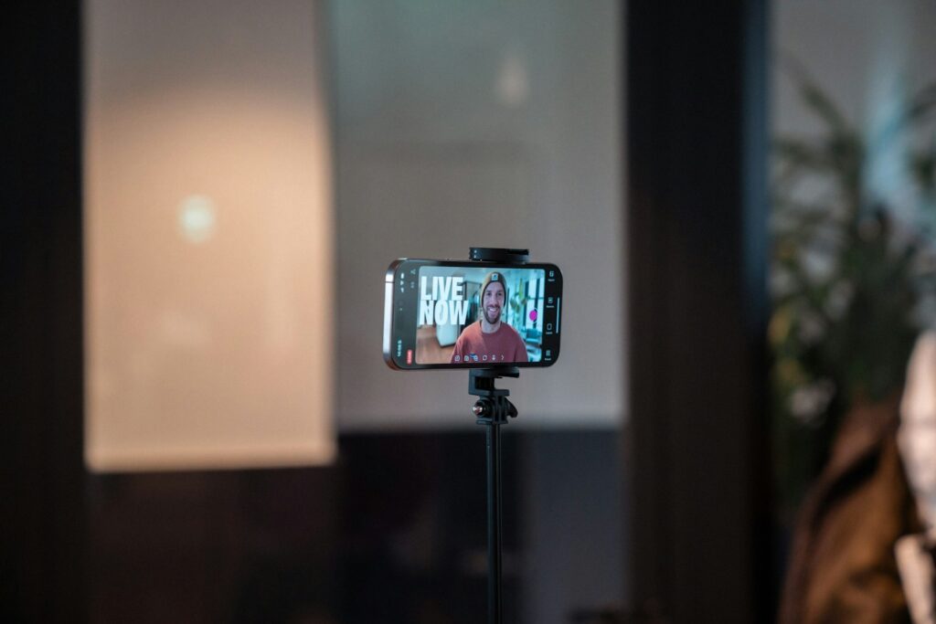 Smartphone auf einem Stativ filmt eine Person – Creator-Produktion als Baustein im Gen Z Marketing