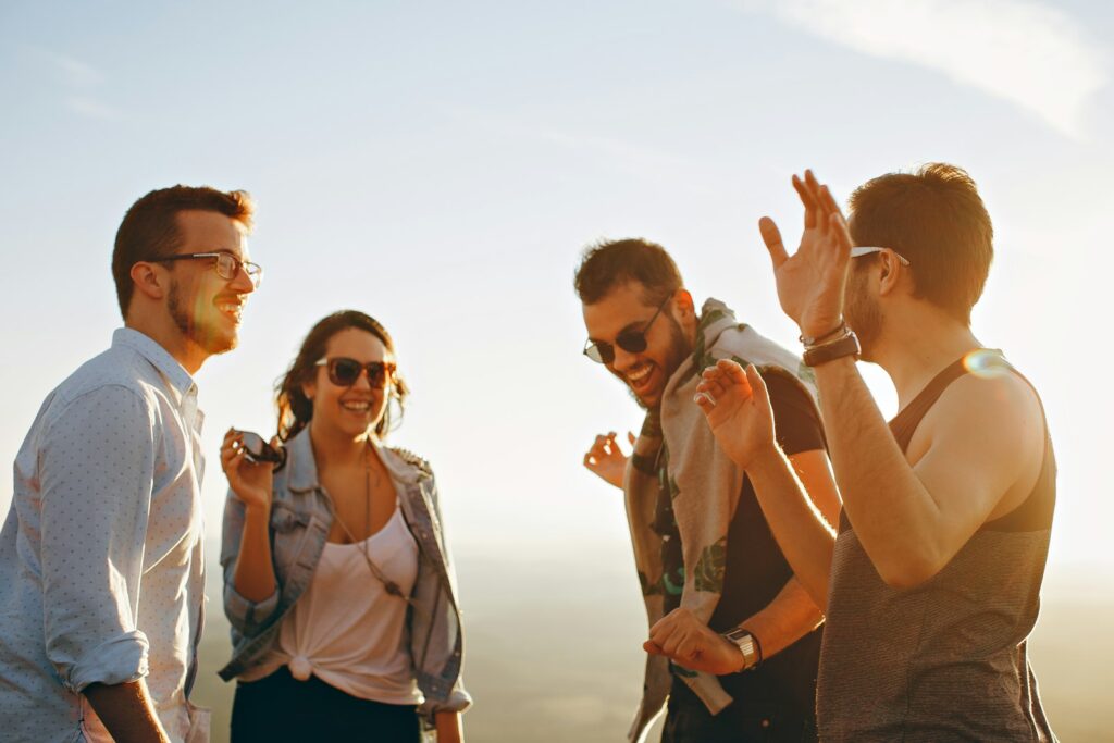 Vier junge Menschen lachen gemeinsam im Freien – Gemeinschaft als Ziel von Gen Z Marketing