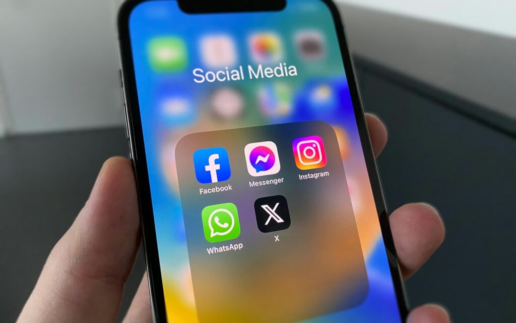 Person hält ein Smartphone mit Social-Media-Ansicht