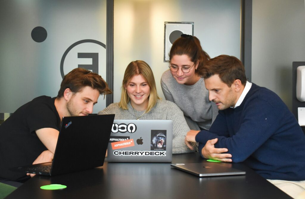 Vier Personen besprechen am Laptop die Wochenauswertung der Google Search Console