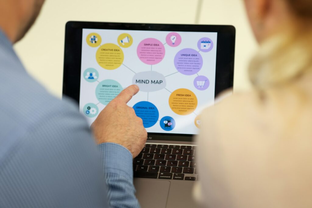 Zwei Personen betrachten eine Mindmap auf dem Laptop als Plan für die interne Verlinkung