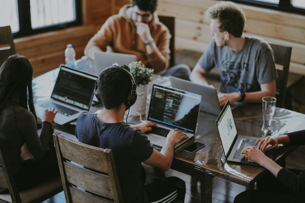 Team bespricht am Laptop die Ergebnisse von KI-Agenten vor der Freigabe
