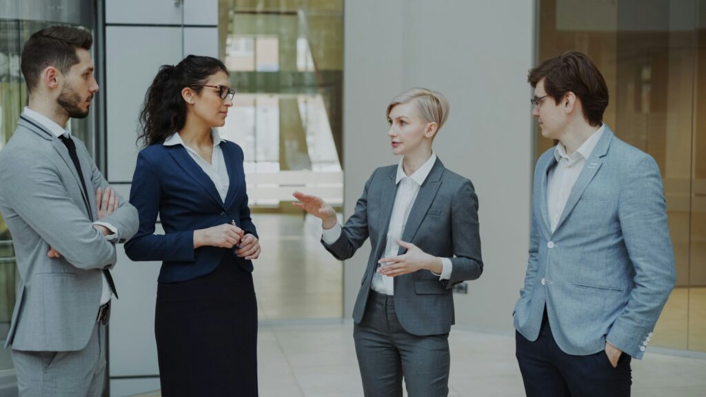 Vier Geschäftsleute besprechen im Büro Ideen für die gemeinsame Kommunikation auf LinkedIn