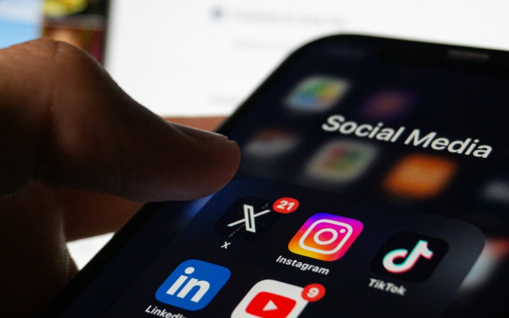 Person hält ein Smartphone mit geöffneter Social-Media-App