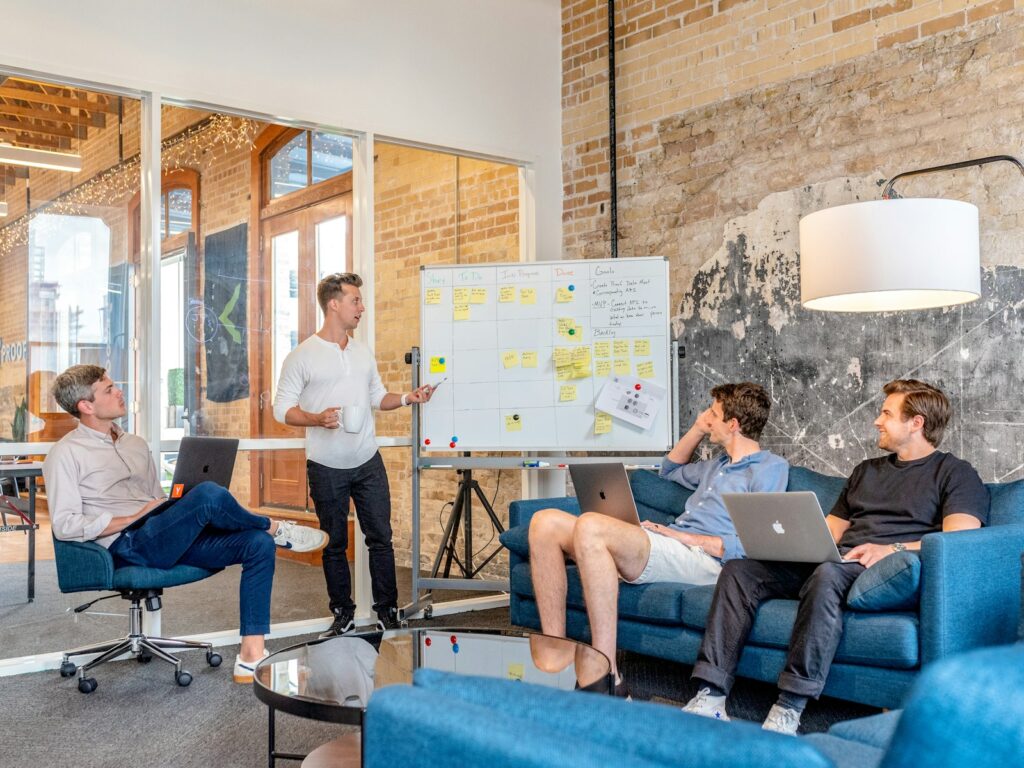 Marketingteam sitzt mit Laptops vor einem Whiteboard und bewertet gemeinsam Marketing Trends 2027