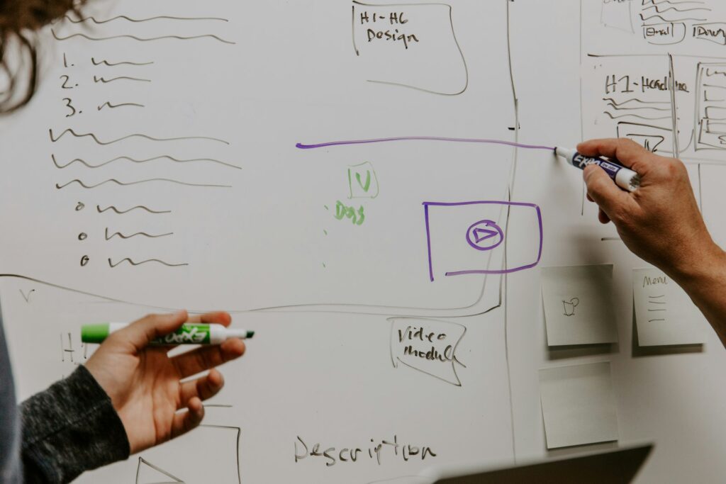 Zwei Personen skizzieren am Whiteboard die Prioritäten der Marketingleitung