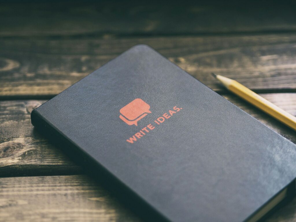 Notizbuch mit der Aufschrift Write Ideas als Sinnbild für eine Prompt-Bibliothek im Content-Team