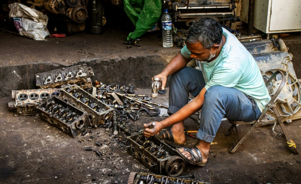 Mechaniker zerlegt in einer Werkstatt Motorteile – Reparierbarkeit als prüfbares Versprechen im Purpose Marketing
