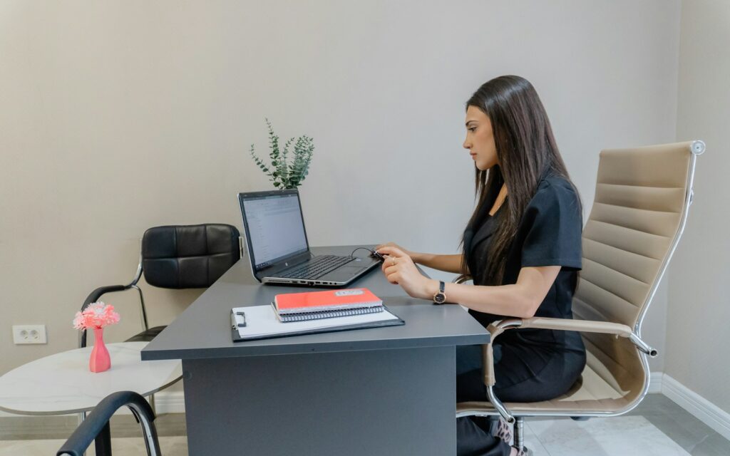 Frau arbeitet im Büro am Laptop