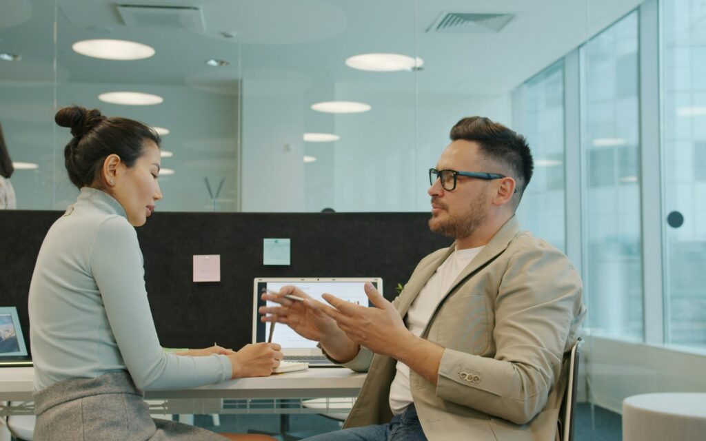 Zwei Kollegen besprechen sich in einem modernen Büro