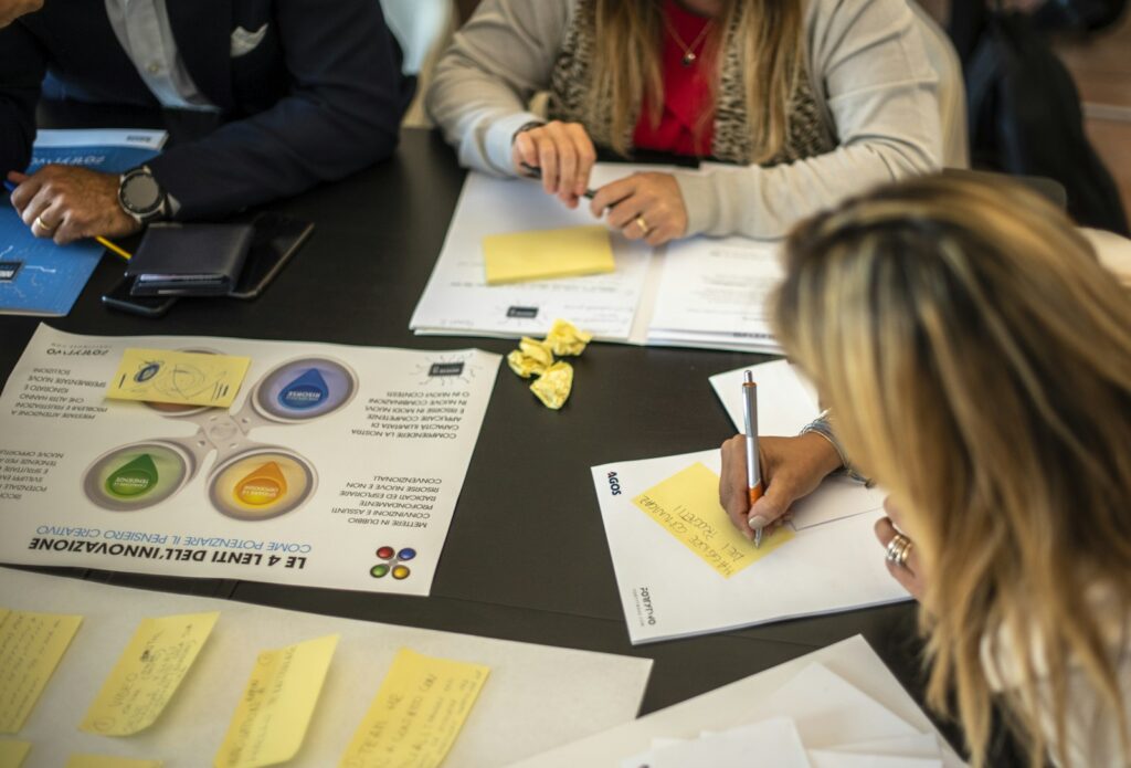 Gruppe arbeitet in einem Workshop am Tisch mit Unterlagen zur Weiterbildung im Marketing